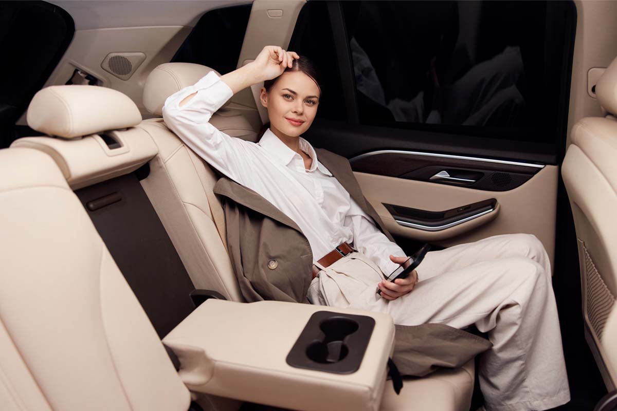 Happy client looking out the window of a chauffeur vehicle