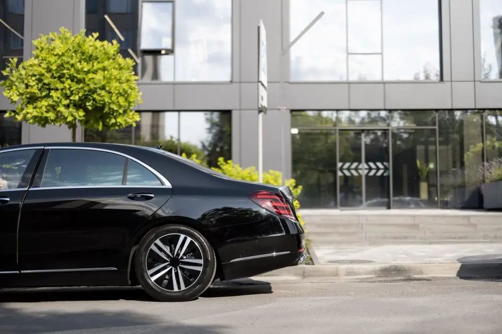Black luxury chauffeur car parked on a London street, illustrating chauffeur cost factors
